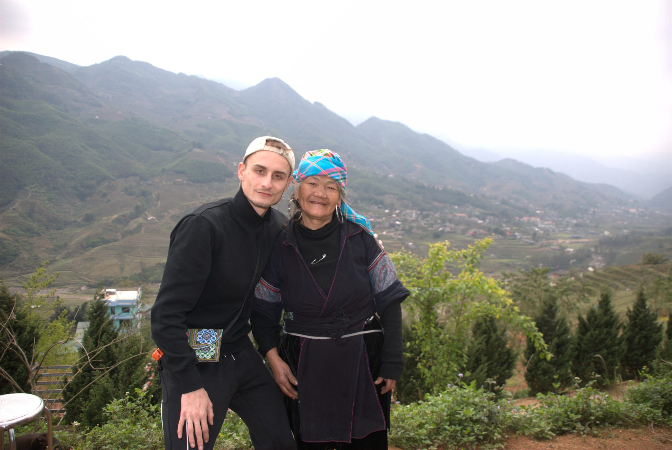Theo Baillieu posant avec une habitante de l'ethnie Hmong en tenue traditionnelle devant sa maison à la fin du trek dans les montagnes du nord du Vietnam, Sa Pa, lors d’un voyage sur mesure authentique